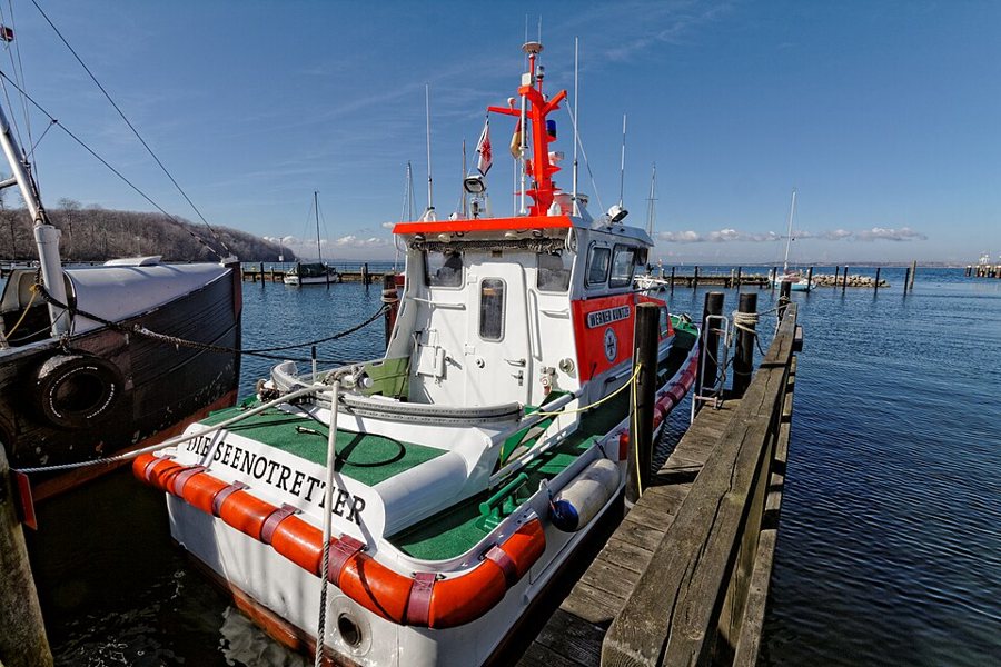 Das weiß-orange Seenotrettungsboot WERNER KUNTZE liegt im Hafen von Langballigau.