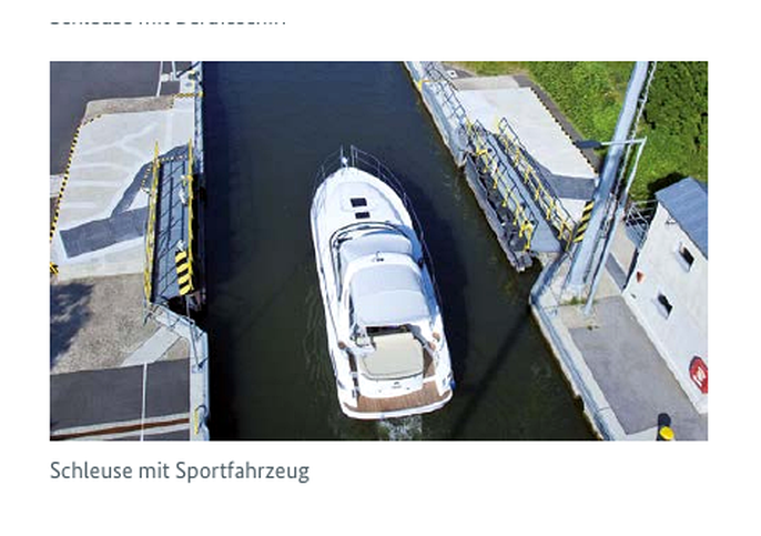 Schleuse mit Sportfahrzeug - Motorboot an der Schleusenwand festgemacht.