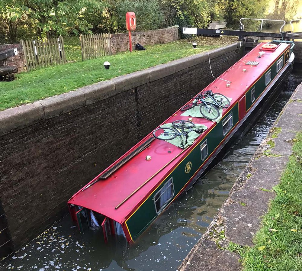 Das Hausboot mit vollständig unter Wasser gedrücktem Bug in der Schleusenkammer.
